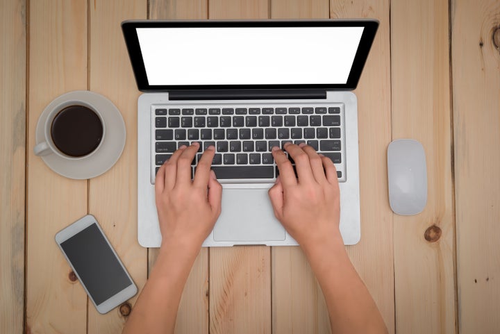 A woman types on her laptop computer.