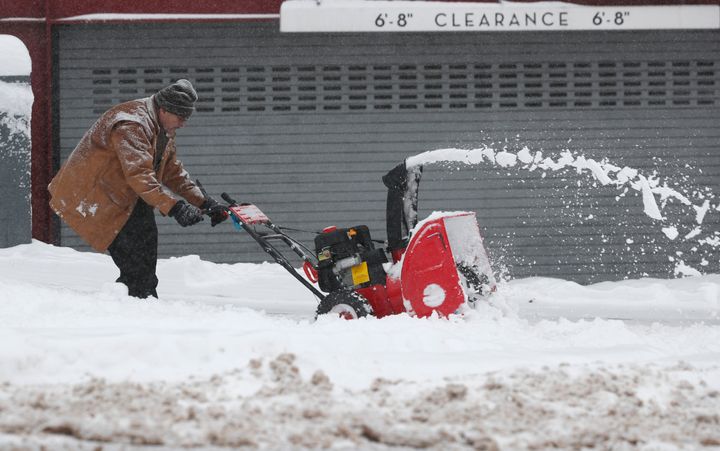 A maintenance man uses a snowblower to clear a sidewalk outside a condominium complex along Grant Street as a storm packing snow and high winds sweeps in over the region on Nov. 26, 2019, in Denver. 