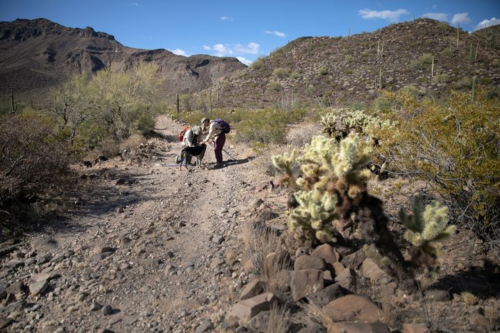 Volunteers for the humanitarian aid group No More Deaths pause while delivering water along remote trails on May 11, 2019 nea