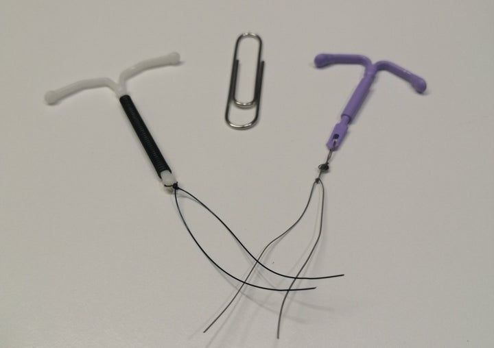 Dos DIU junto a un clip para apreciar su tamaño. 