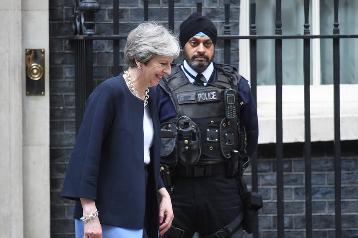 Theresa May passes a Sikh policeman on guard outside 10 Downing Street