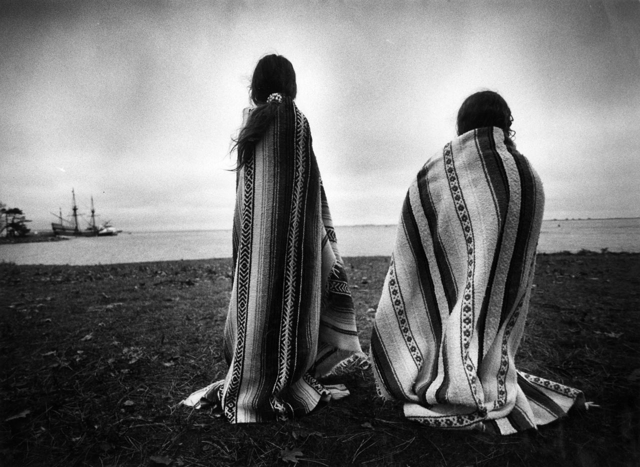 Πλίμουθ Ημέρα των Ευχαριστιών. Δύο νεαρές Ιθαγενείς Αμερικάνες κοιτάζουν την ρεπλίκα του Mayflower, του πλοίου που έφερε τους πρώτους Ευρωπαίους αποίκους. Για τους ινδιάνους η Ημέρα των Ευχαριστιών είναι Ημέρα Πένθους.