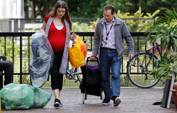 A woman is helped with her belongings from the Burnham Tower, part of the Chalcots Estate on June 26, 2017