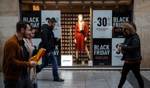Des piétons passant devant un magasin annonçant les soldes du Black Friday, à Caen,...
