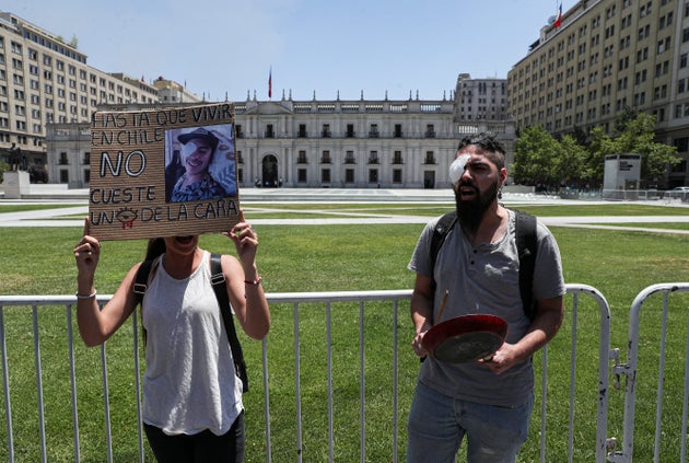 A woman holds a sign that reads in Spanish: 