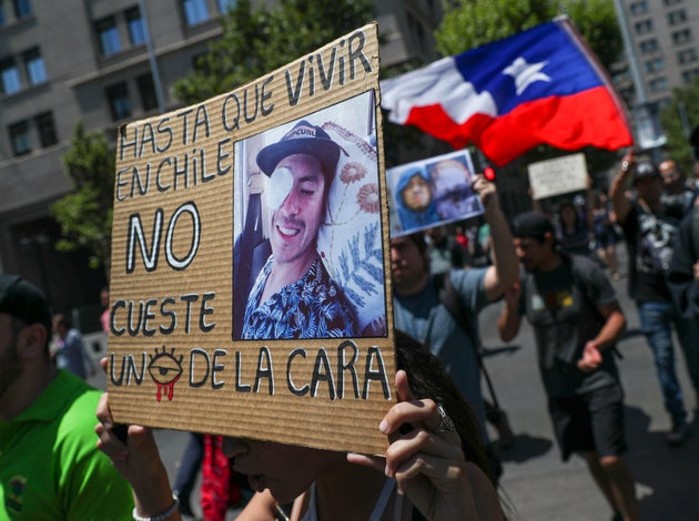 A woman holds a sign that reads in Spanish: 