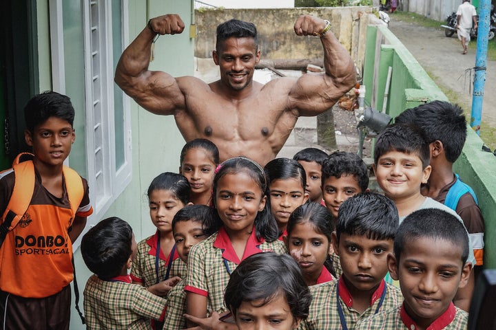 Chitharesh poses for a photo with children from a local school who came to meet 'the man who has put Kerala on the map'.