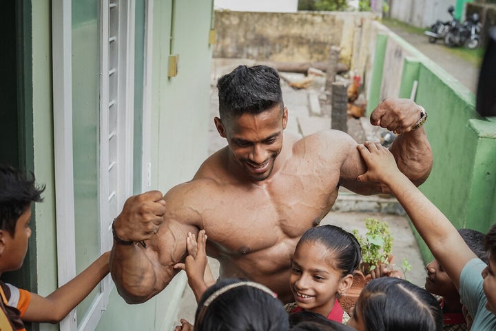 Chitharesh answers the children's questions and lets them feel his biceps.