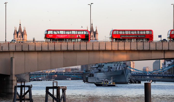 A police boat on the River Thames as abandoned buses are parked on London Bridge 