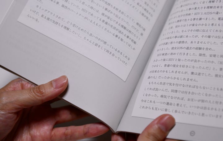 HIV感染について自ら書いた手記を読む女性＝東京