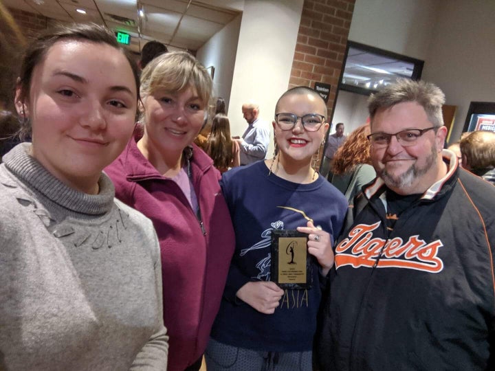 Stecina posing with their family and their award backstage at the pageant.