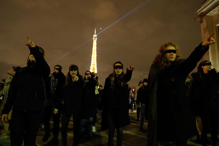 Women wearing black blindfolds take part in a flash mob at the Trocadero esplanade in Paris on November 29, 2019. 
