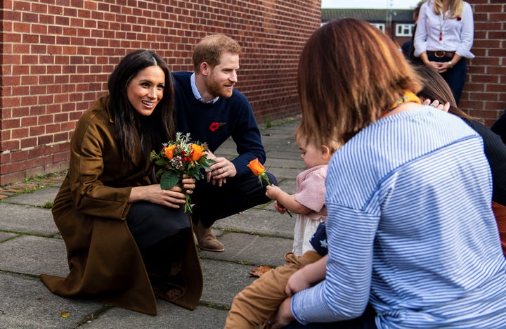 Bonnie and Maggie Emanuel give a posy of flowers to Meghan during a visit at Broom Farm Community Centre in Windsor on Nov. 6. 