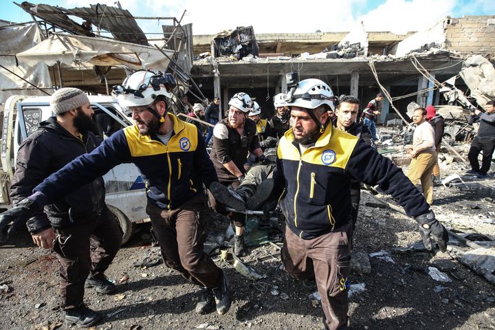 Les Casques blancs de la Défense civile syrienne tirent une victime des débris dans un marché bombardé par les forces du régime de Bachar al-Assad à Idleb, en Syrie, le 2 décembre. L'attaque a fait plusieurs morts et blessés.