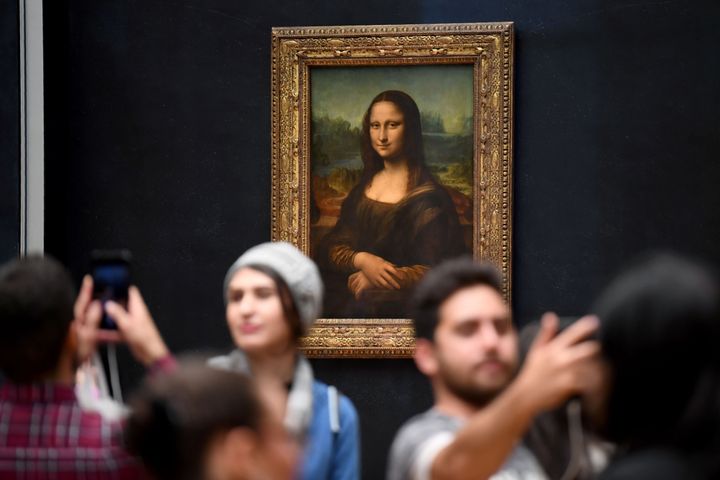 Tourists taking selfies with the Mona Lisa in the Louvre, Paris.