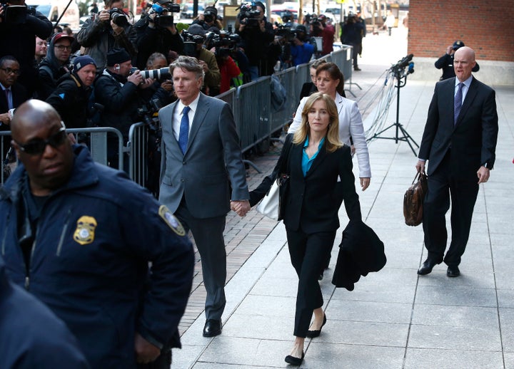 Felicity Huffman, in blue shirt at center, leaves the John Joseph Moakley United States Courthouse in Boston on April 3, 2019.