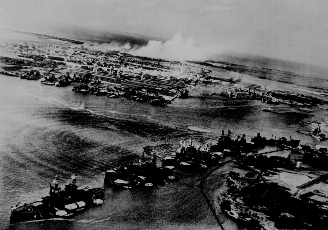 真珠湾攻撃で、奥のヒッカム飛行場から白煙が上がる。