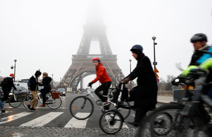 People ride bicycles near the Eiffel Tower during a strike by all unions of the Paris transport network (RATP) as part of a day of national strike and protests against French government's pension reform plans, on Dec. 5, 2019. 