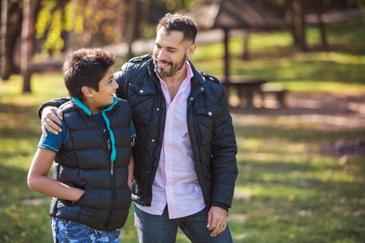 Father and son walking together and having a confidential conversation.