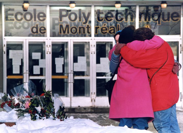 Three women hug each other after laying flowers in front of the Polytechnical School at the University of Montreal on Dec. 9, 1989.