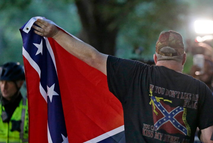 A man displays a Confederate flag during a rally regarding the recently vandalized Confederate monument known as Silent Sam at the University of North Carolina in Chapel Hill, N.C., Thursday, Aug. 30, 2018. (AP Photo/Gerry Broome)