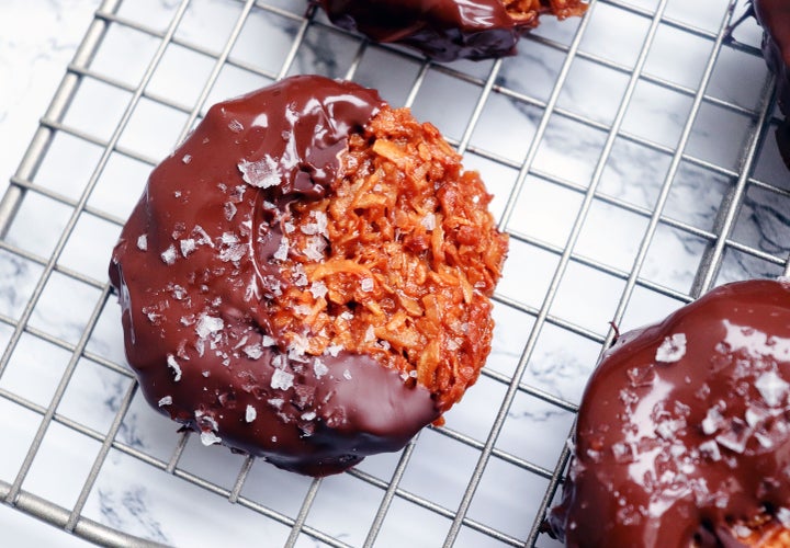 DIY Samoa cookies dipped in melted chocolate and garnished with flaky sea salt.