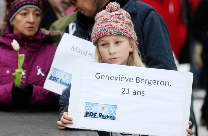 A young girl holds up a placard with the name of one of the victims of the Polytechnique massacre at a vigil in Montreal. 