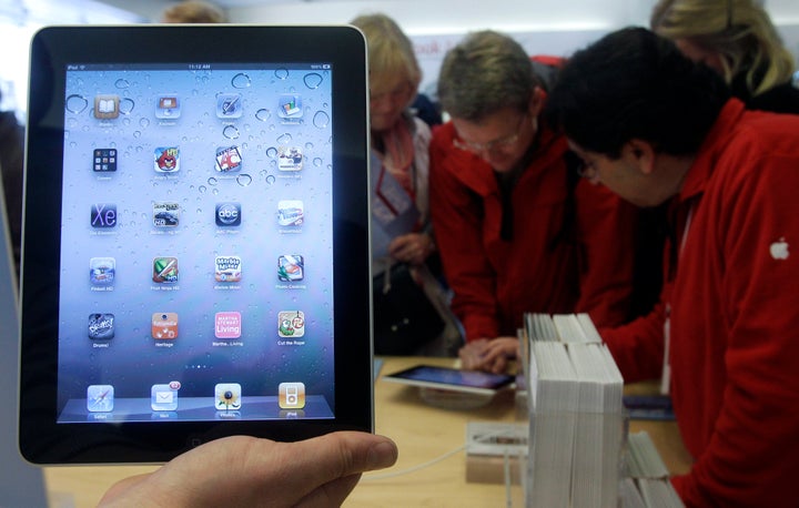 In this Nov. 26, 2010 file photo, a store employee holds up an iPad at an Apple Store in San Francisco.