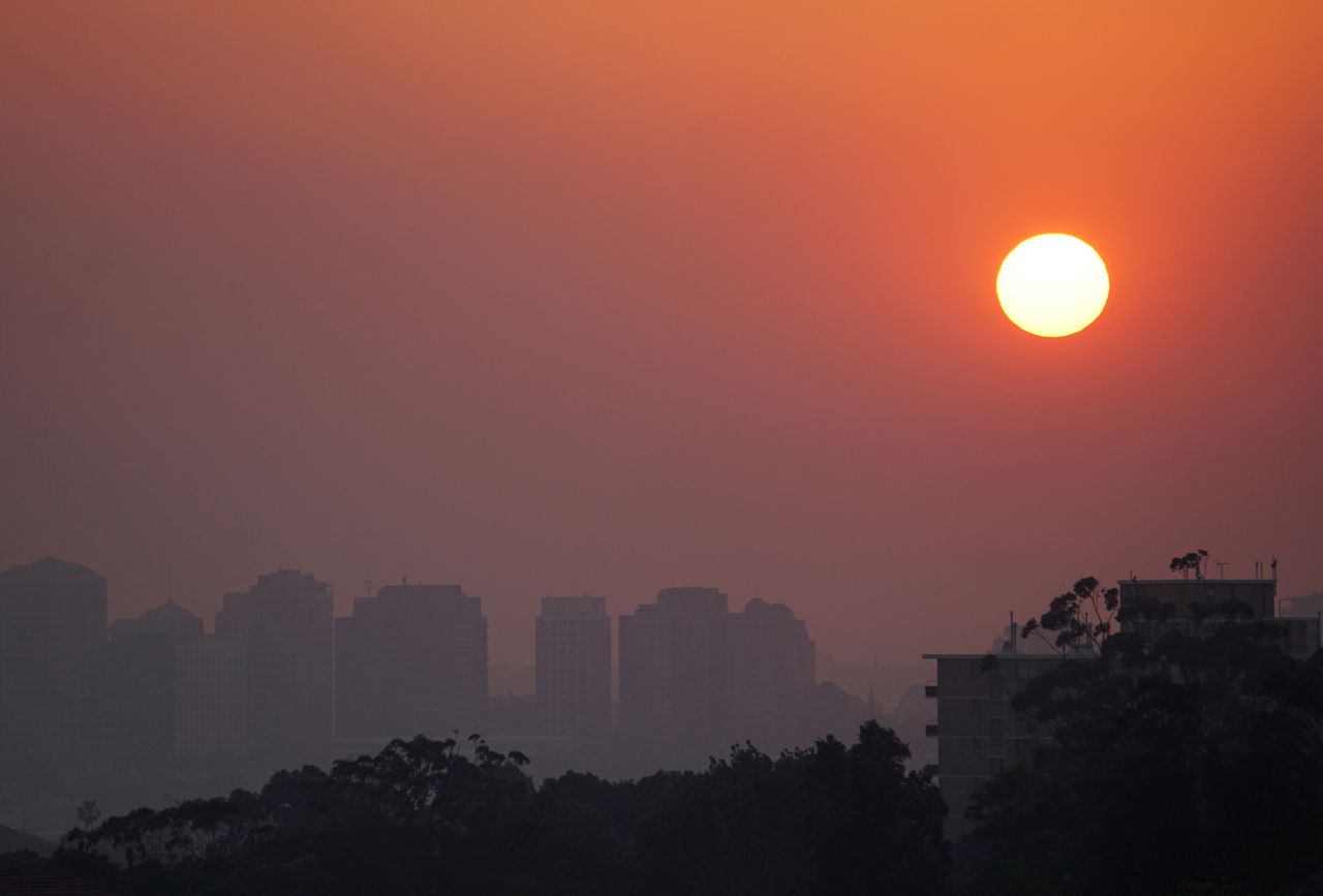 High-rise buildings seen through smoke from bushfires during sunset in Sydney.