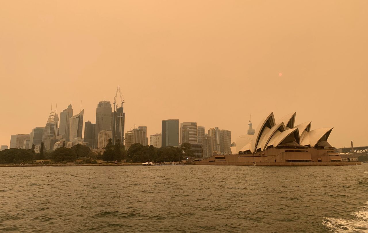 Haze from the bushfires obscures the sun setting above the Sydney Opera House.
