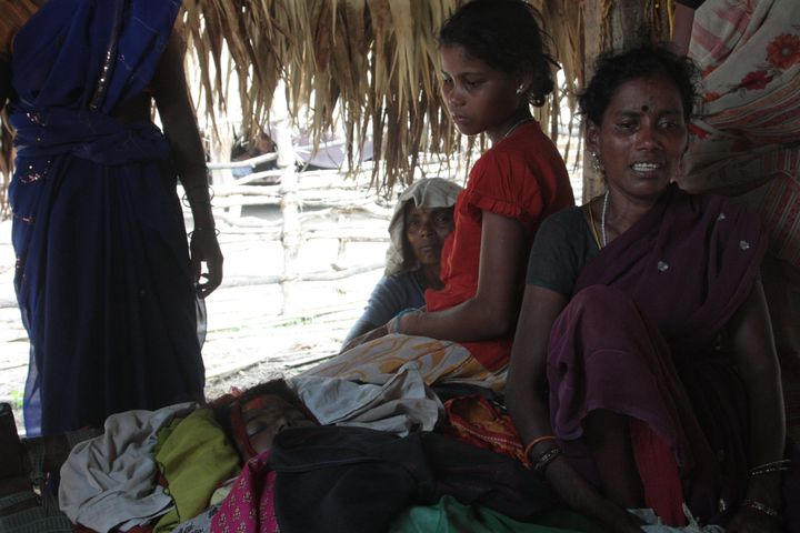 The family of 12 year old Kaka Saraswati sit by her corpse. Seventeen villagers were killed by Indian security forces in June 2012 in Chhattisgarh.