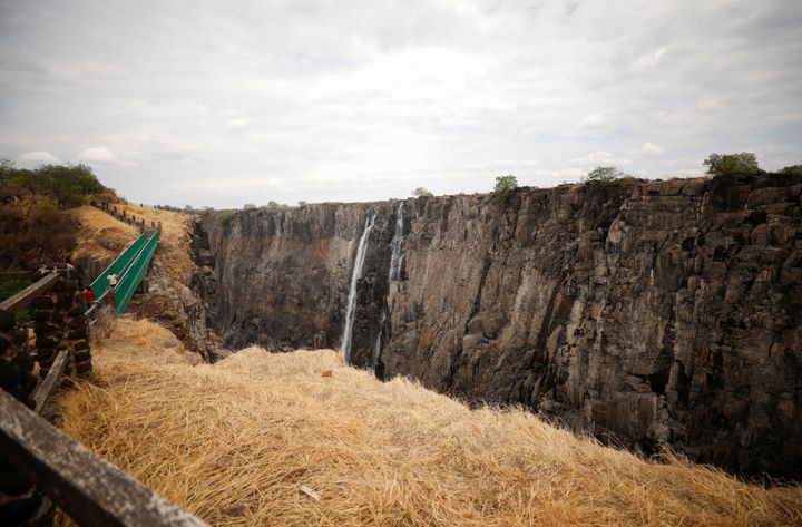 Visitors walk over the bridge at Victoria Falls, which is currently suffering from extreme drought. 