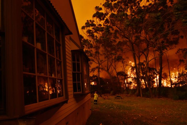 Fire fighting crews from the Rural Fire Service (RFS), NSW Fire and Rescue and National Parks and Wildlife Service (NPWS) officers fight a bushfire encroaching on properties near Lake Tabourie, Australia, December, 5, 2019. AAP Image/Dean Lewins/via REUTERS