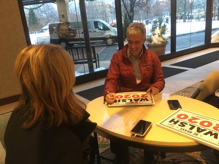 The GOP presidential hopeful and his wife, Helene Walsh, sign campaign posters in New Hampshire.