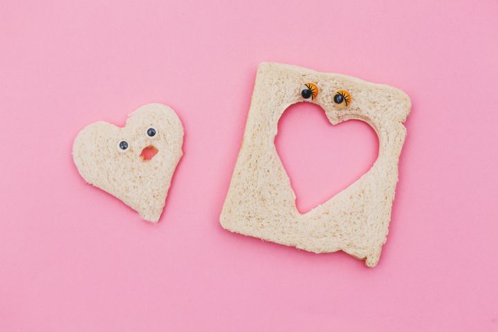 heart shape piece of bread couple in pink background