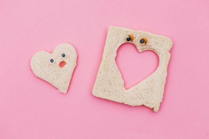 heart shape piece of bread couple in pink background