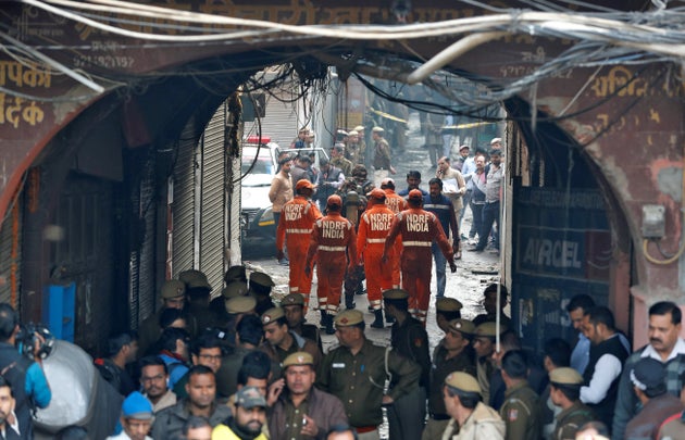 Members of India's National Disaster Response Force (NDRF) head towards the site of the fire. 