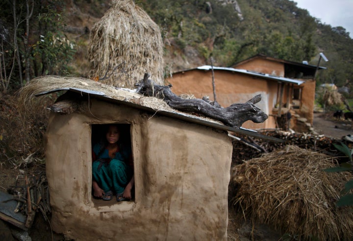 A 14-year-old girl sits inside a chhaupadi shed in the hills of Legudsen village in Achham district in western Nepal in 2014.