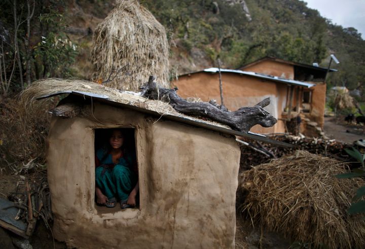 A 14-year-old girl sits inside a chhaupadi shed in the hills of Legudsen village in Achham district in western Nepal in 2014.