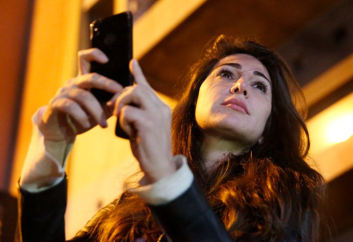 In this Wednesday, Dec. 4, 2019 photo, Lebanese anchorwoman Dima Sadek uses her cellphone to film an anti-government protest,