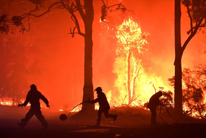 Rural Fire Service (RFS) volunteers and NSW Fire and Rescue officers fight a bushfire encroaching on properties near Termeil, Australia.