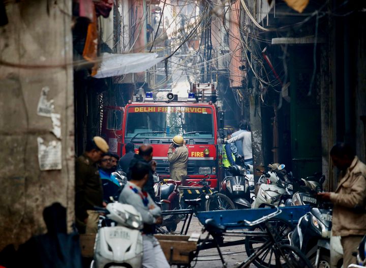 A fire engine stands by the site of a fire in an alleyway, tangled in electrical wire and too narrow for vehicles to access, in New Delhi, Dec. 8, 2019. 
