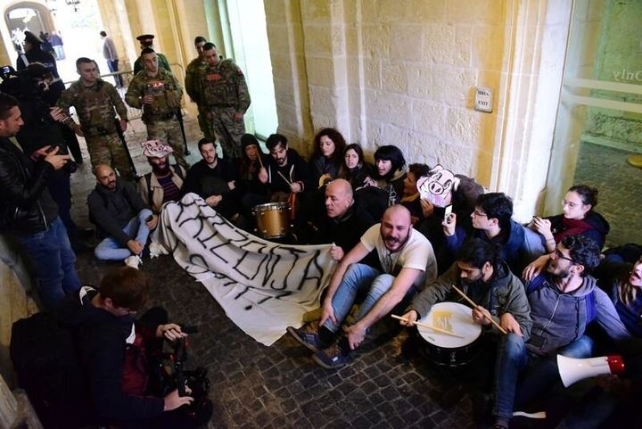 Activists sit after having barged into the building of Malta's Prime Minister Joseph Muscat's office, demanding his resignation in the wake of developments in case of the 2017 murder of anti-corruption journalist Daphne Caruana Galizia, in Valletta