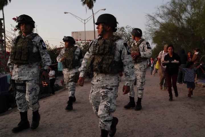 The Mexican National Guard patrols an encampment where asylum-seekers live as their tents are relocated from the plaza to near the banks of the Rio Grande in Matamoros on Dec. 7, 2019.