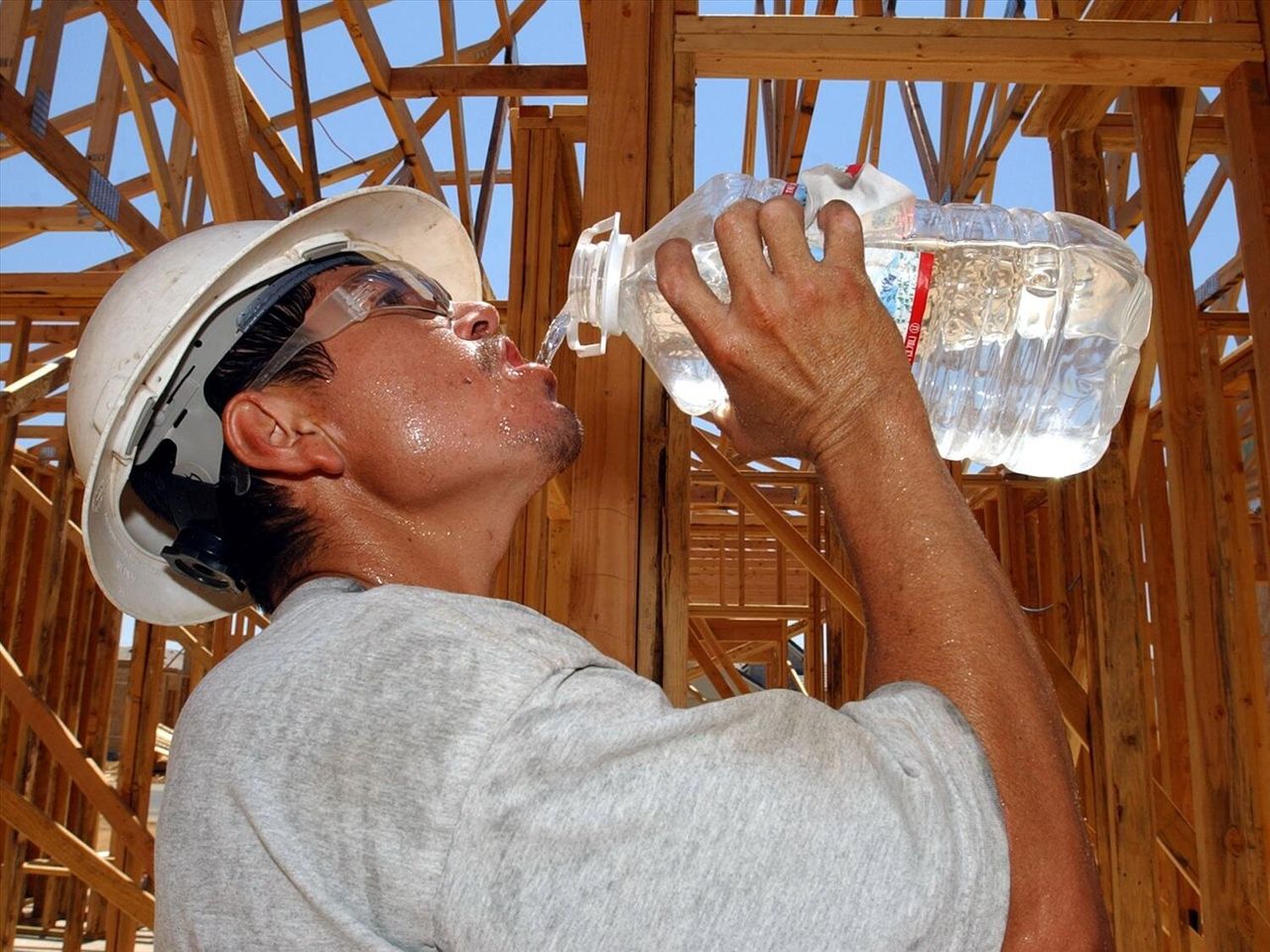 A construction worker drinks a bottle of water while working on a site in Rancho Cordova, California.