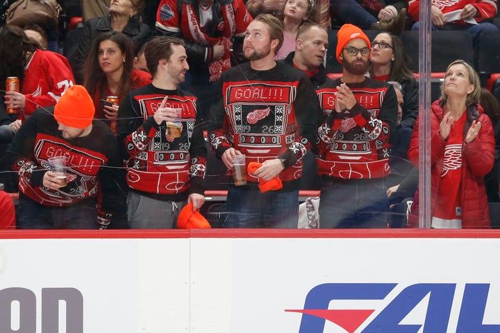 Detroit fans wearing matching Red Wing-themed ugly Christmas sweaters at a game on Dec. 22, 2018.