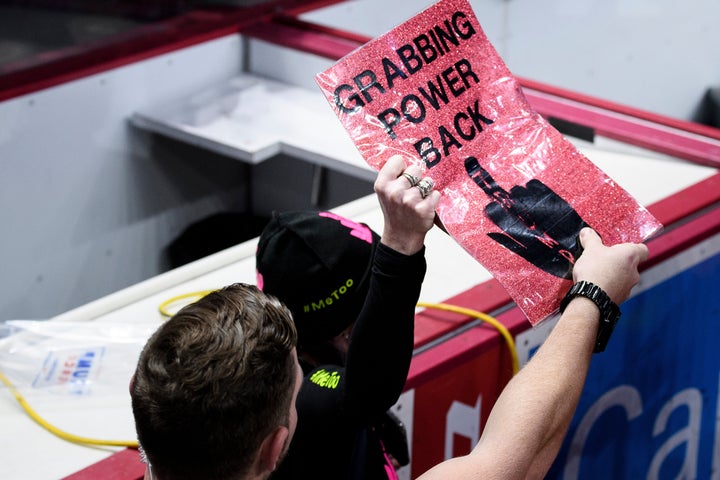 Security reaches for a protester's sign as President Trump speaks during a Keep America Great rally at the Giant Center in Hershey, Pennsylvania on December 10, 2019.