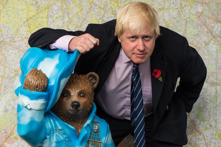 Boris Johnson, posando con una estatua del Oso Paddington en Londres.