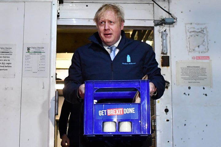 Boris Johnson carries a crate of milk while campaigning for the general election.