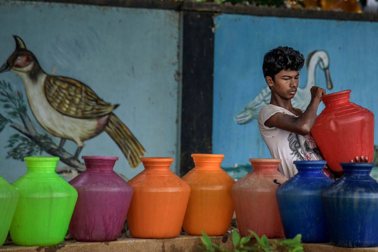 A boy carries water cans being filled at the Metro water filling station in the heart of Chennai on June 30, 2019. All four major reservoirs supplying water to the city had dried up.